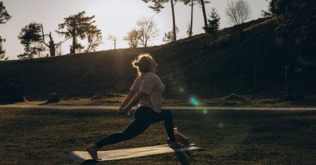 Frau macht Yoga in der Natur bei Sonnenuntergang – Bewegung und frische Luft unterstützen Gesundheit und Wohlbefinden