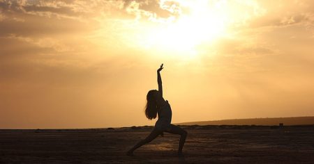 Silhouette einer Frau beim Yoga in der Abendsonne – Symbol für Bewegung und Herzgesundheit