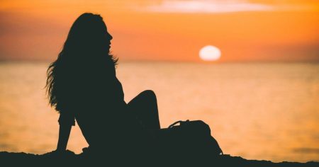 Alzheimer: Entzündung löschen – Risiko senken! Frau sitzt im Sonnenuntergang am Meer – Symbol für Ruhe, Lebensfreude und geistige Klarheit.