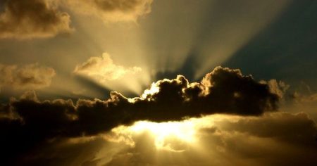 Dramatische Gewitterwolken mit durchbrechendem Sonnenlicht als Symbol für Leber unter Feuer und inneren Kampf des Körpers